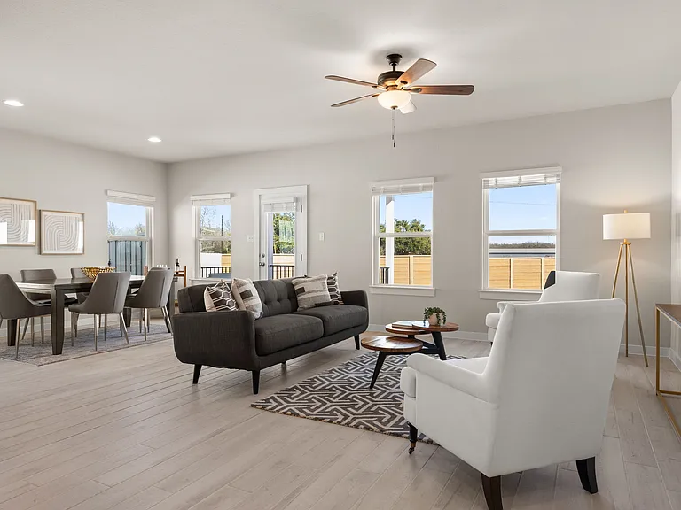 Light and airy, open plan living/dining area with lots of windows and door that opens onto a covered back porch.