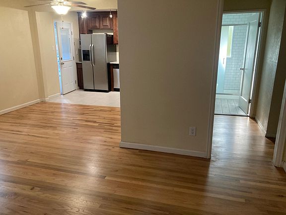 Standing inside the front door, Living, Dining, and kitchen on left; bathroom, closet (with laundry) and bedrooms to the right.