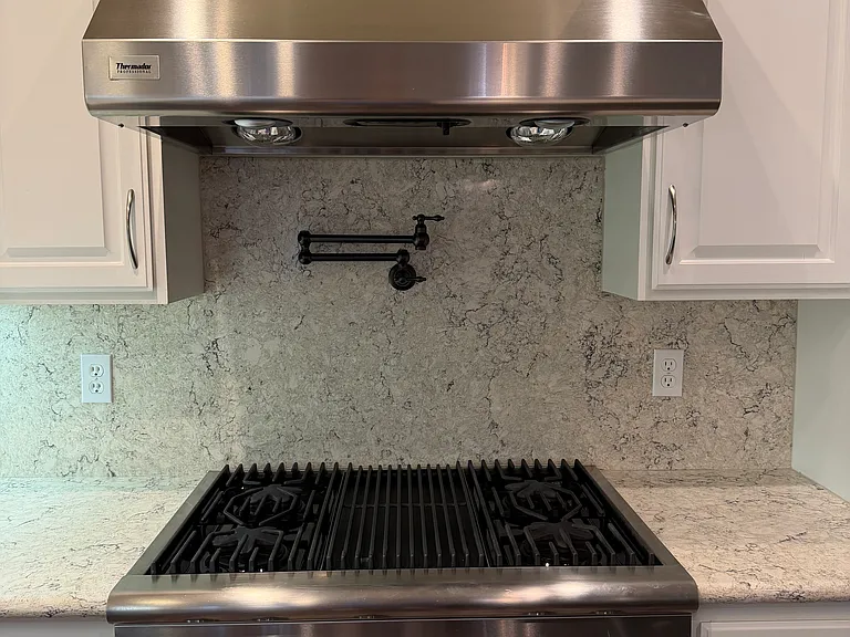 Thermador gas cooktop with stainless steel hood with heat lamps; beautiful pot filler to easily fill stock pots