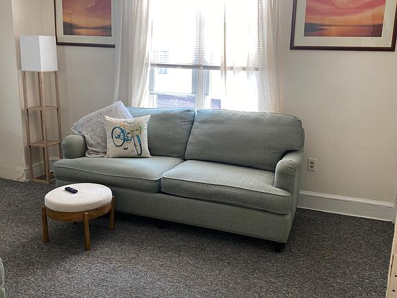 Spacious living room with two cozy couches and mounted TV.