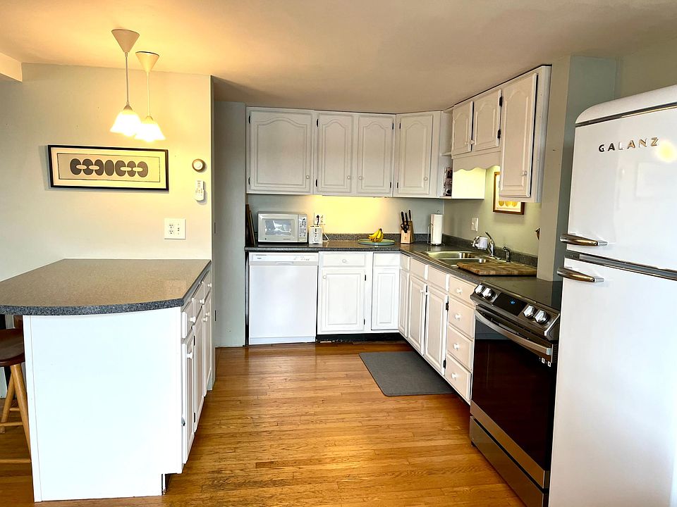 Fully stocked kitchen with microwave, stove, fridge, toaster, and coffee maker.