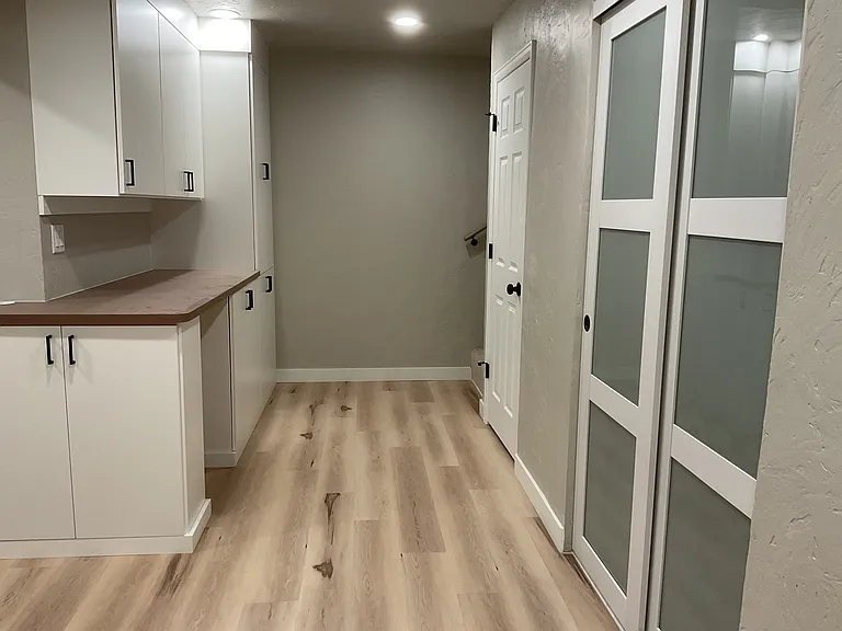 Newly built basement storage cabinetry on the left with a built in countertop designed to be multi functional which can serve as a desk area w/ the addition of a counter stool or, a condiment station w/ the addition of a small refrigerator.