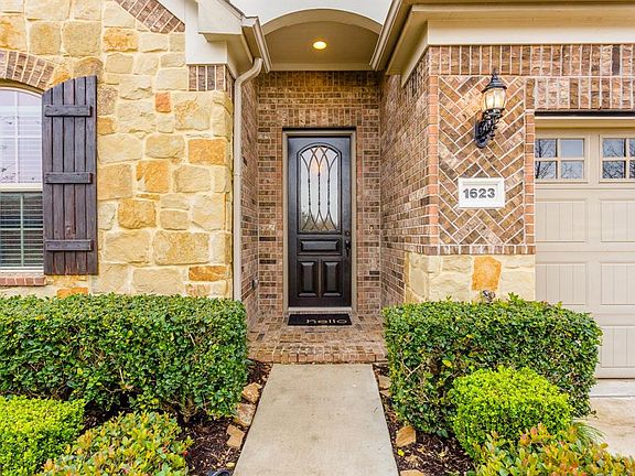 The covered brick front porch and handsome front door with leaded glass invites you in to this great home.