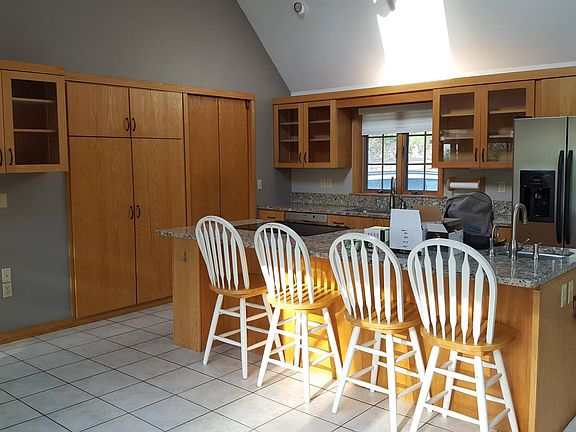 Kitchen, with chairs at counter. Laundry room off kitchen.