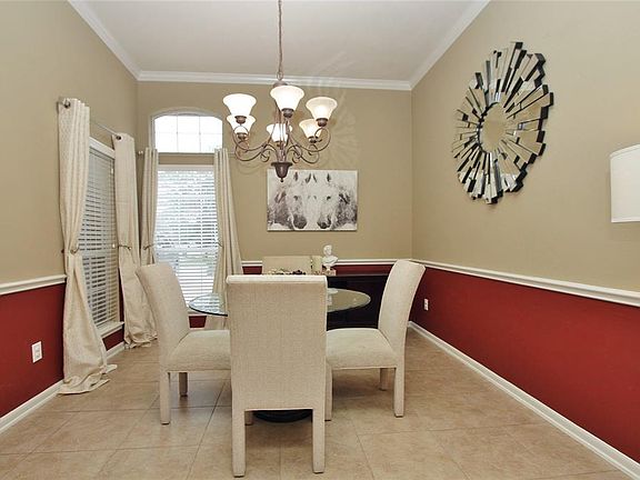 The Dining Room features high ceilings, tile floors and gorgeous designer colors contrasted with chair rail.