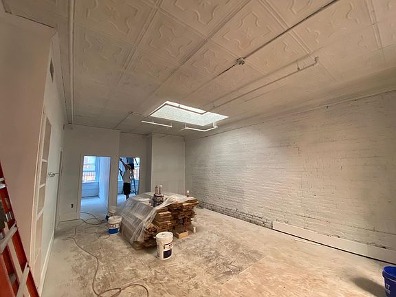 Living room with exposed brick. Oak hardwood floors coming soon!
