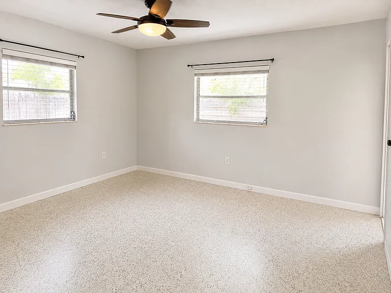 Bedroom #2 with one cedar closet and pocket door to Sunroom. Terazzo floors.