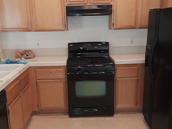 Kitchen with gas range, oven, dishwasher, and fridge.