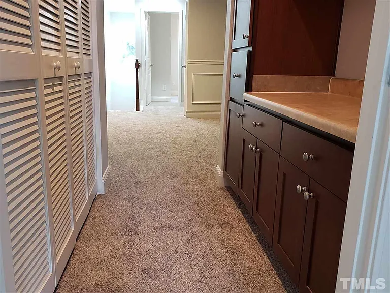 Walkway before entering the private master bedroom. Washer Dryer on the left and bar/cabinet space with ample storage