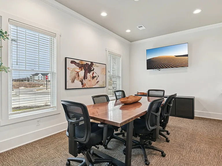 Elevate your next brainstorming session in this bright conference room, featuring a wooden table and a serene view that makes every meeting feel a little more inspired.