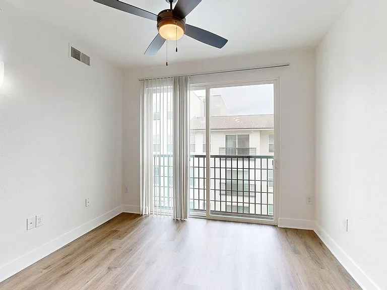 Apartment living room with balcony and wood style floors.