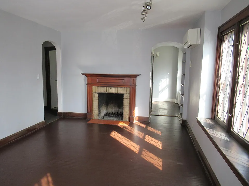 Living room, arches leading to hallway (left) and dining room (right)