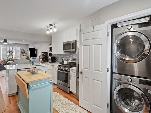 Renovated kitchen with white cabinetry, stainless steel appliances, quartz counters.