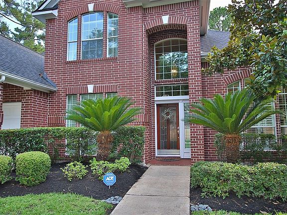 Traditional red brick and arched and soldered window accents with keystone accent stone. Wood and lead glass entry door with sidelight.