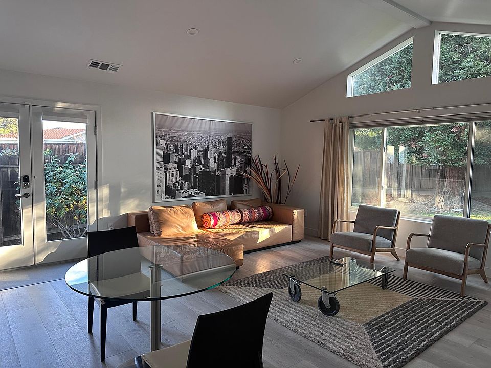 Light filled Living room with large windows and entry door.