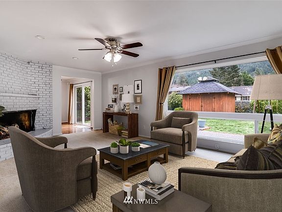 Large living room with a cozy gas fireplace and open to the dining room.  (This picture has been digitally staged.)