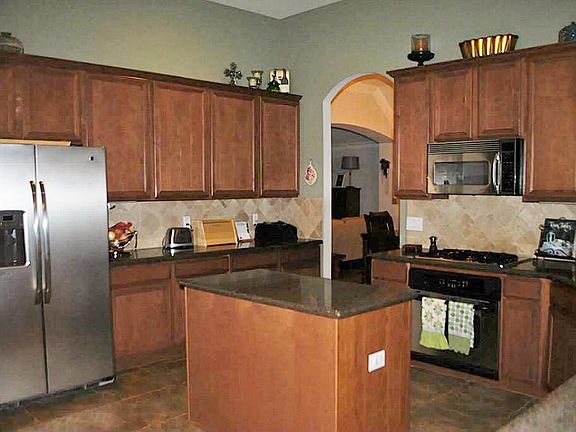 The large island kitchen features stainless appliances and a skylight that allows in plenty of natural light.