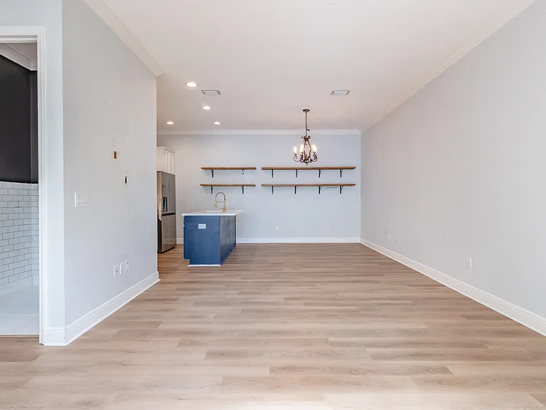 Here, you can see the large living area that leads to the kitchen, and to the left is the remodeled half bathroom.