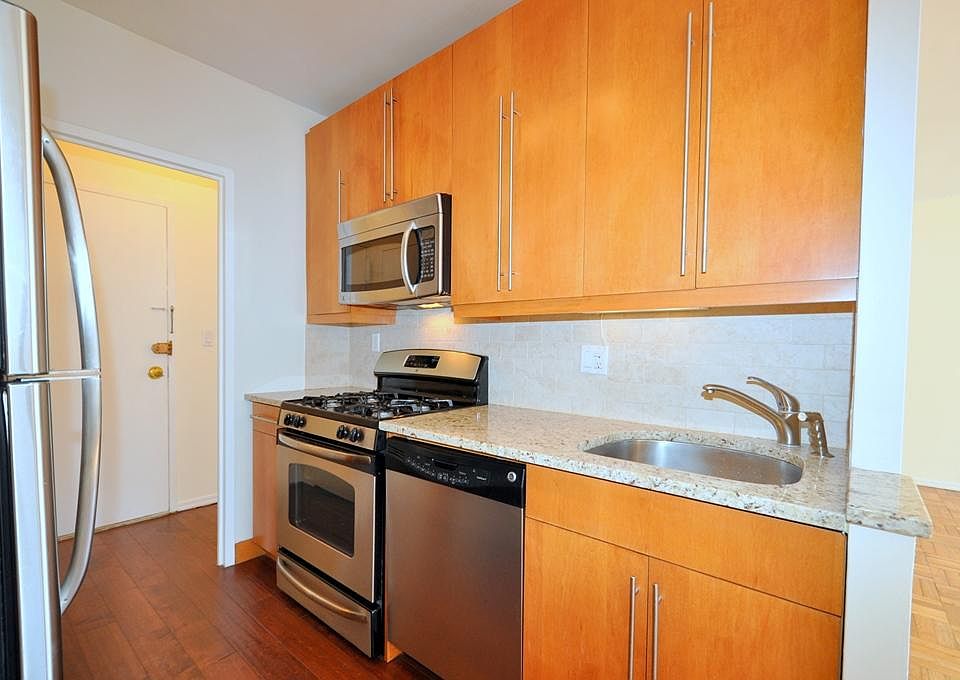Updated Kitchen with Granite Counters, custom cabinets and stainless steel appliances including a dishwasher, microwave, range and refrigerator.