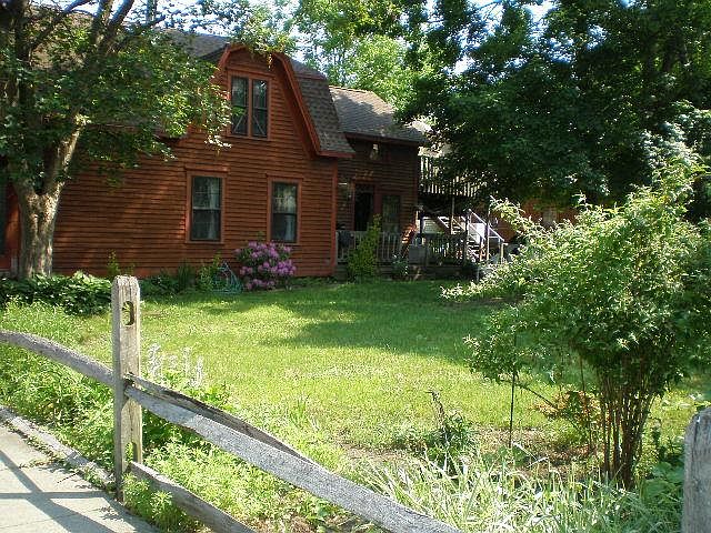 Front of house and view of yard and deck in the back.
