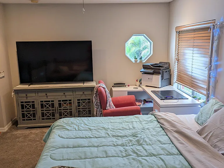 The loft provides a quaint getaway for those in need of a private workspace, reading area or otherwise. The octagon window overlooks the driveway of the home, the window with blinds overlooks the side driveway.