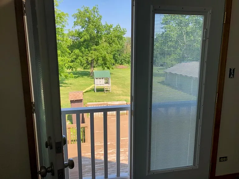 Rear upstairs bedroom with French doors overlooking backyard