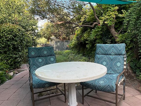 small bistro set outside apartment front door, near fountain that birds like to visit regularly