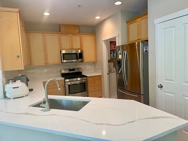 Upgraded kitchen with quartz countertop, tile backsplash and waterproof flooring