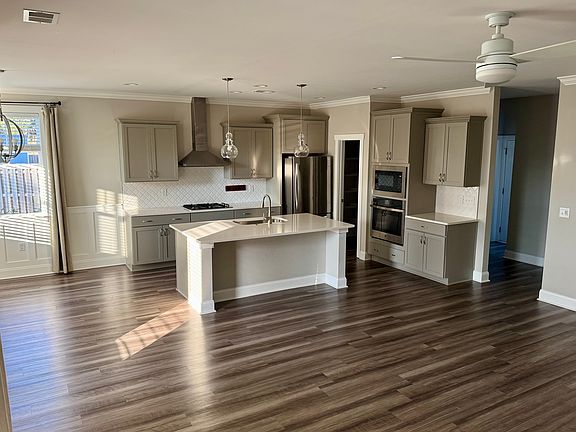 Kitchen with gas cooktop and walk in pantry. Kitchen is open to the family room and has a dining area.