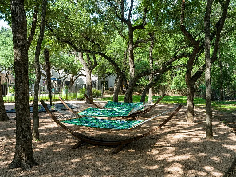 Shaded hammocks tucked beneath mature oaks_your go-to spot for peaceful afternoons at Alister Sunset Valley.