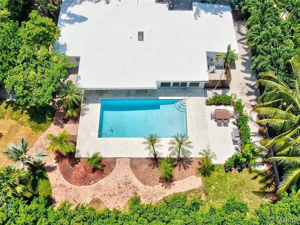 Aerial view of this private oasis on 12,000 SF lot. Fenced, freshly landscaped with oversize pool, outdoor shower, patio and bar b q. Ideal indoor/outdoor living. Perfect for entertaining.