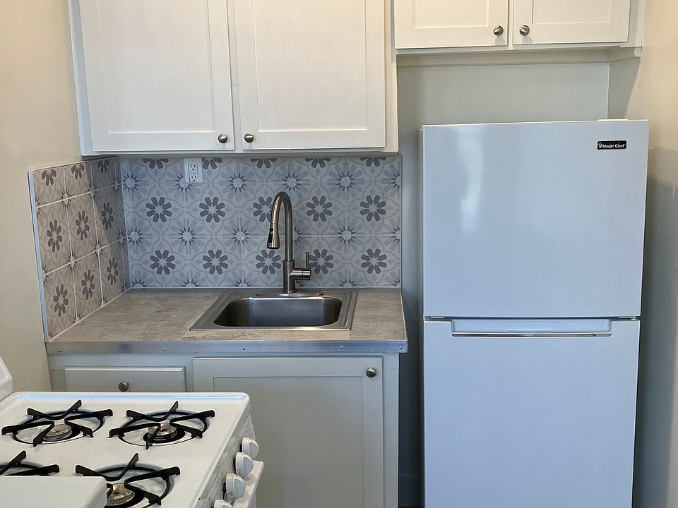 all white kitchen with tile backsplash