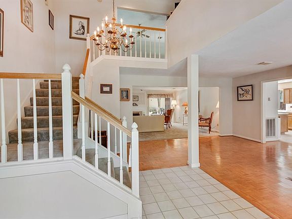 Classic stair case with soft tread carpeting.  Easy care extended tile foyer gives way to parquet flooring .