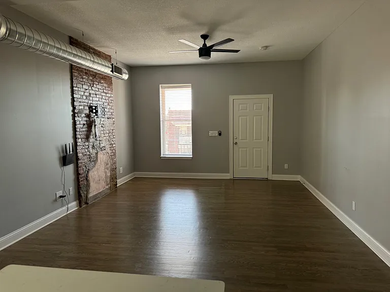 The living room features an open floor plan focusing on the original 1859 brick fireplace. Expand picture to view the detail.