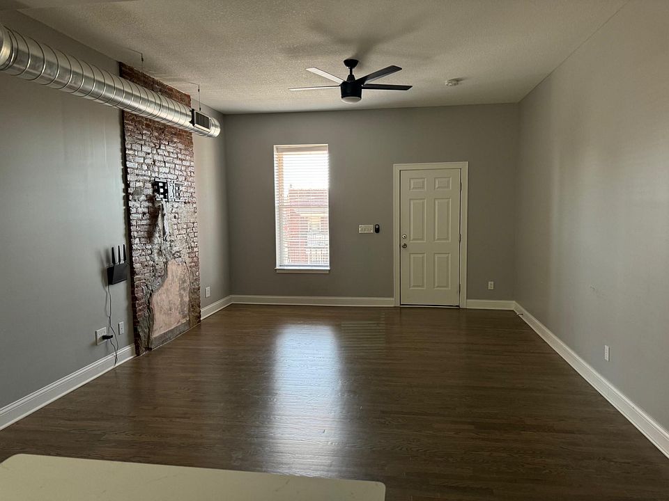 The living room features an open floor plan focusing on the original 1859 brick fireplace. Expand picture to view the detail.