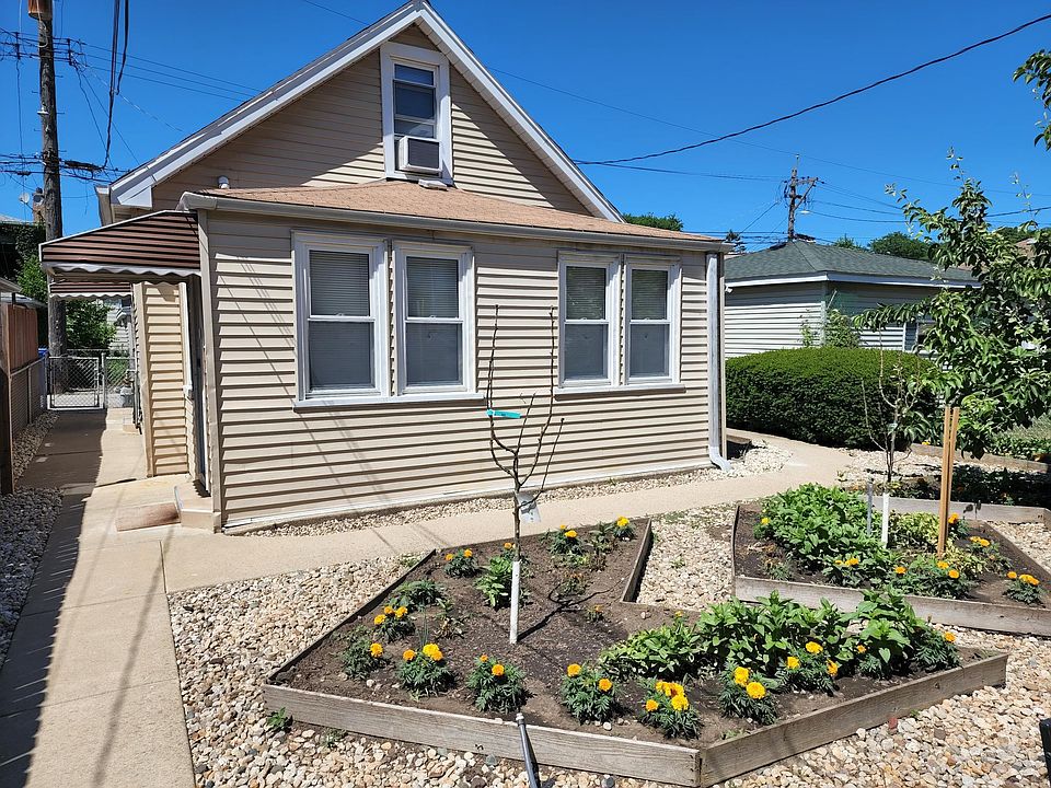 Backyard with vegetable garden and fruit trees. Coach house is pictured here.