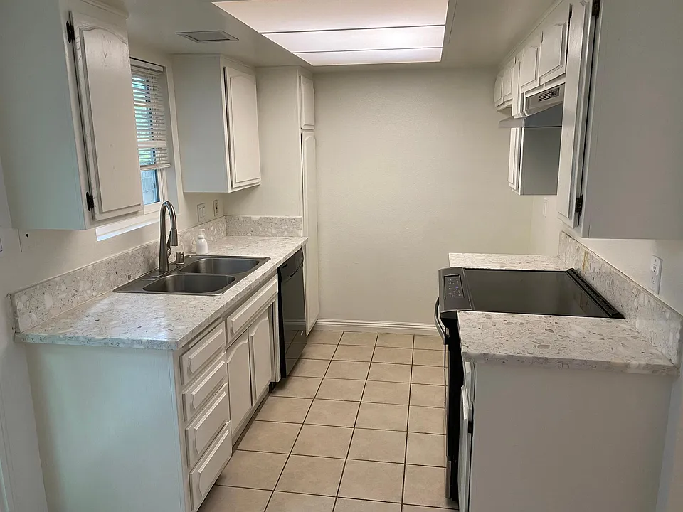 Refinished Kitchen cabinets and new stove hood. Tile flooring.