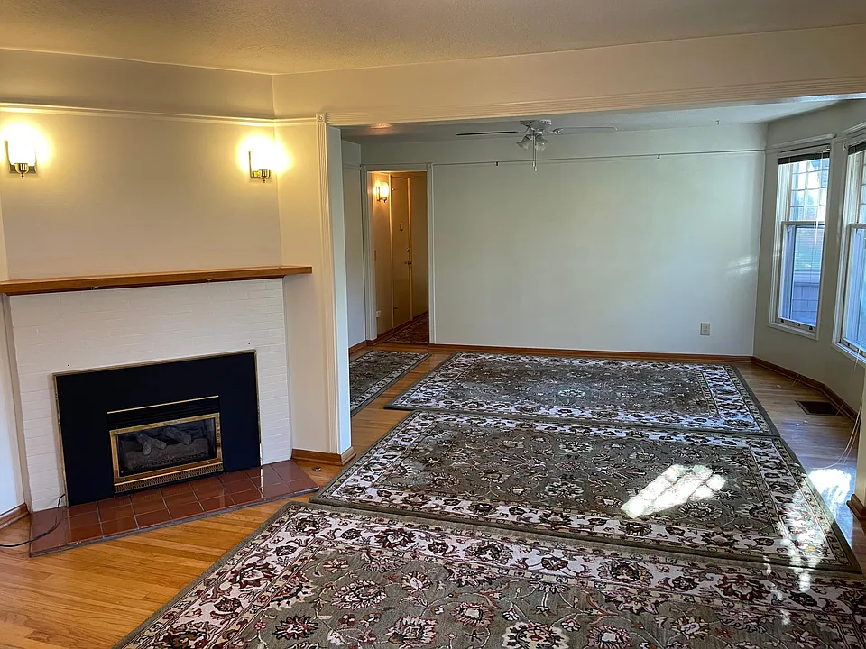 Living room/Dinning room with gas fireplace and big bright windows.