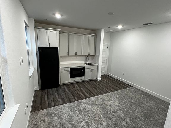 Living area with kitchenette, refrigerator, microwave and countertop induction 2 spot stove included.