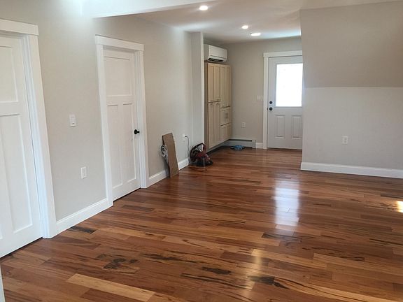 Entrance (with storage closets) and partial living area. Doors to both bedrooms