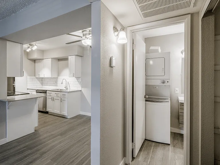 upgraded countertops and white cabinets with hardwood flooring