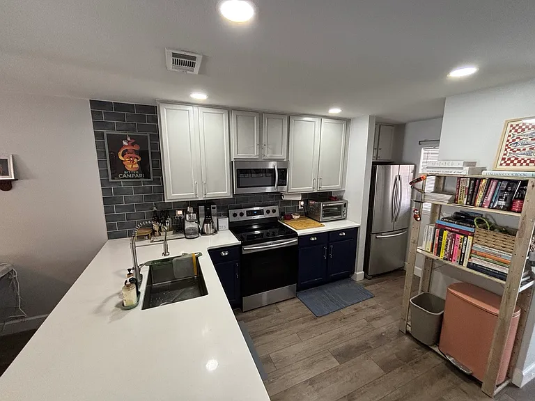 Kitchen with Samsung fridge, range/oven, microwave, and dishwasher. Stainless steel deep sink.
