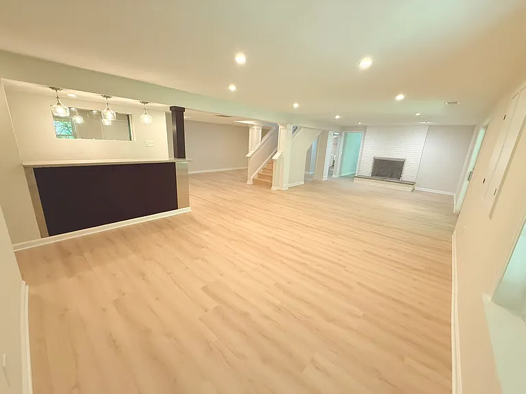 Basement living area facing stairs and bar