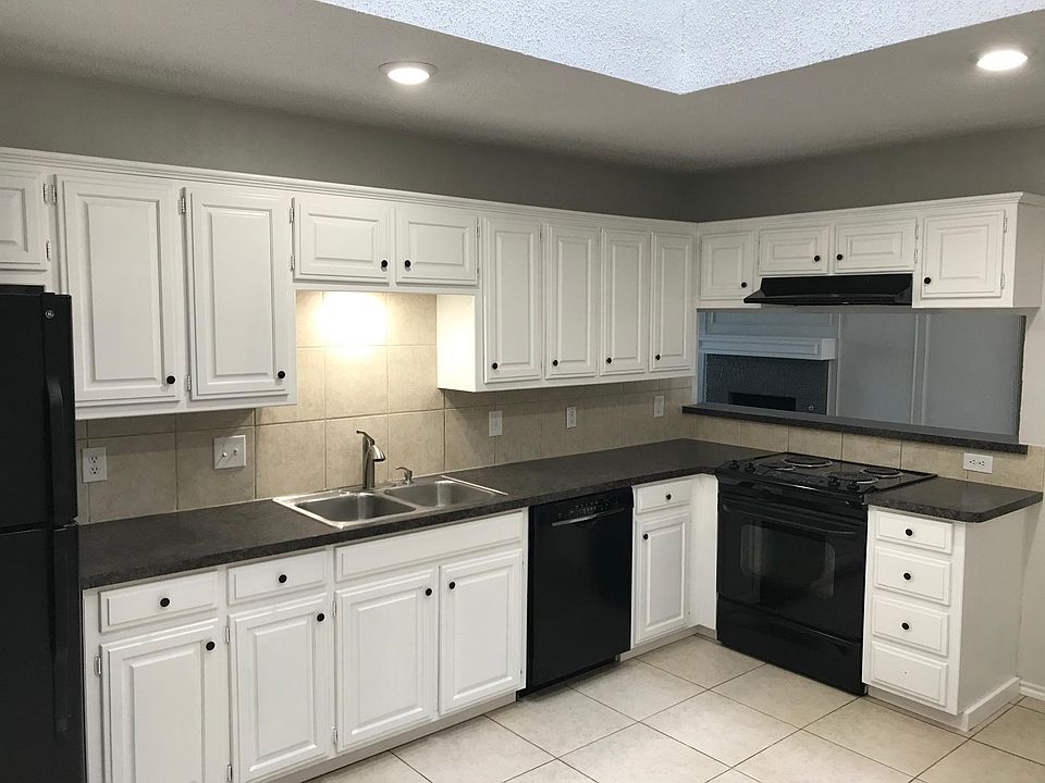 Newly painted kitchen with plenty of cabinet space and small bar area looking into the living room.