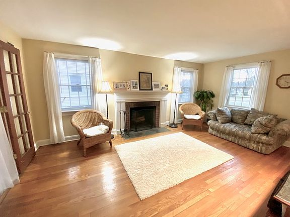 Living room has wood burning fireplace and french doors to family room. All windows have curtains.