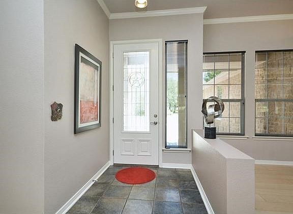 Reminding you that you are in the Great State of Texas, a leaded glass front door opens to a contemp