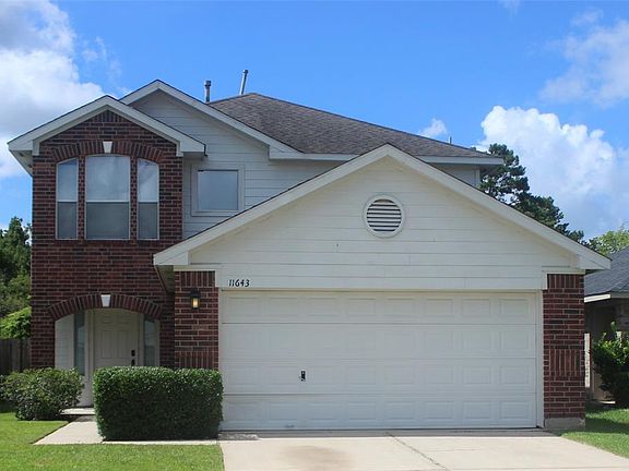 Great dark brick and wood elevation with long driveway.
