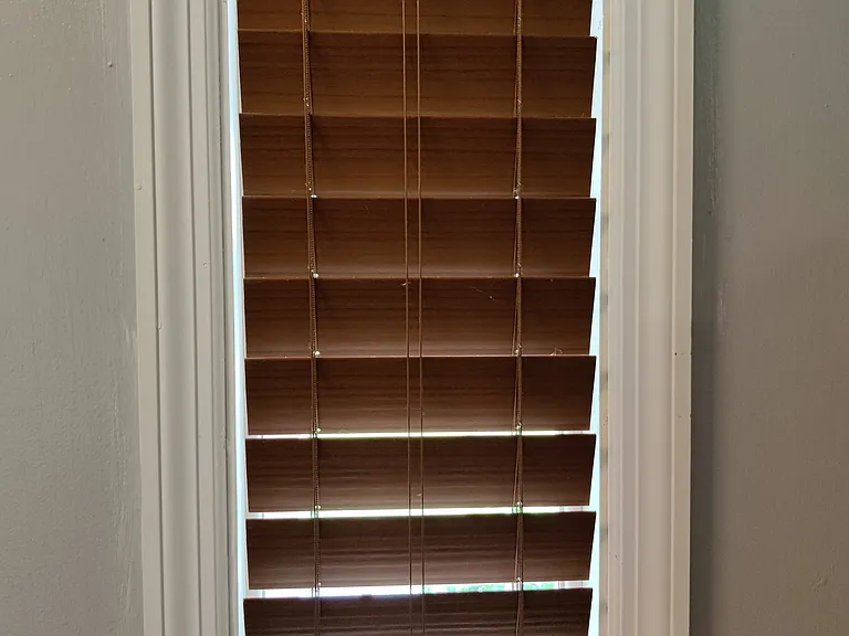 close up of window blinds, they have a wood look and can be raiser or lowered by hand (no string needed)