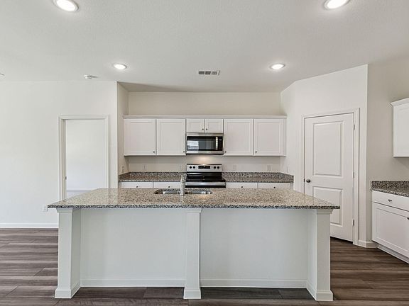Large island in beautiful open kitchen with stainless steel appliances