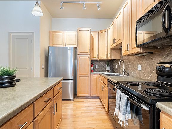Kitchen with Island Counte, Refrigerator and Kitchen Pantry, Stove, Dishwasher and Microwave including Under Counter Lights..